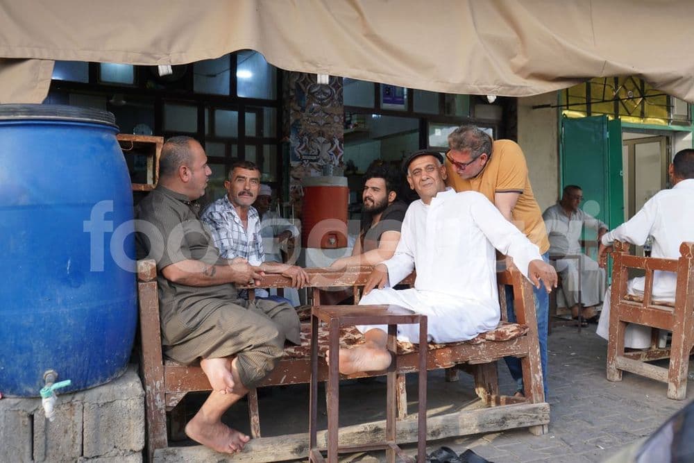 مجموعة اشخاص يجلسون في مقهى شعبي